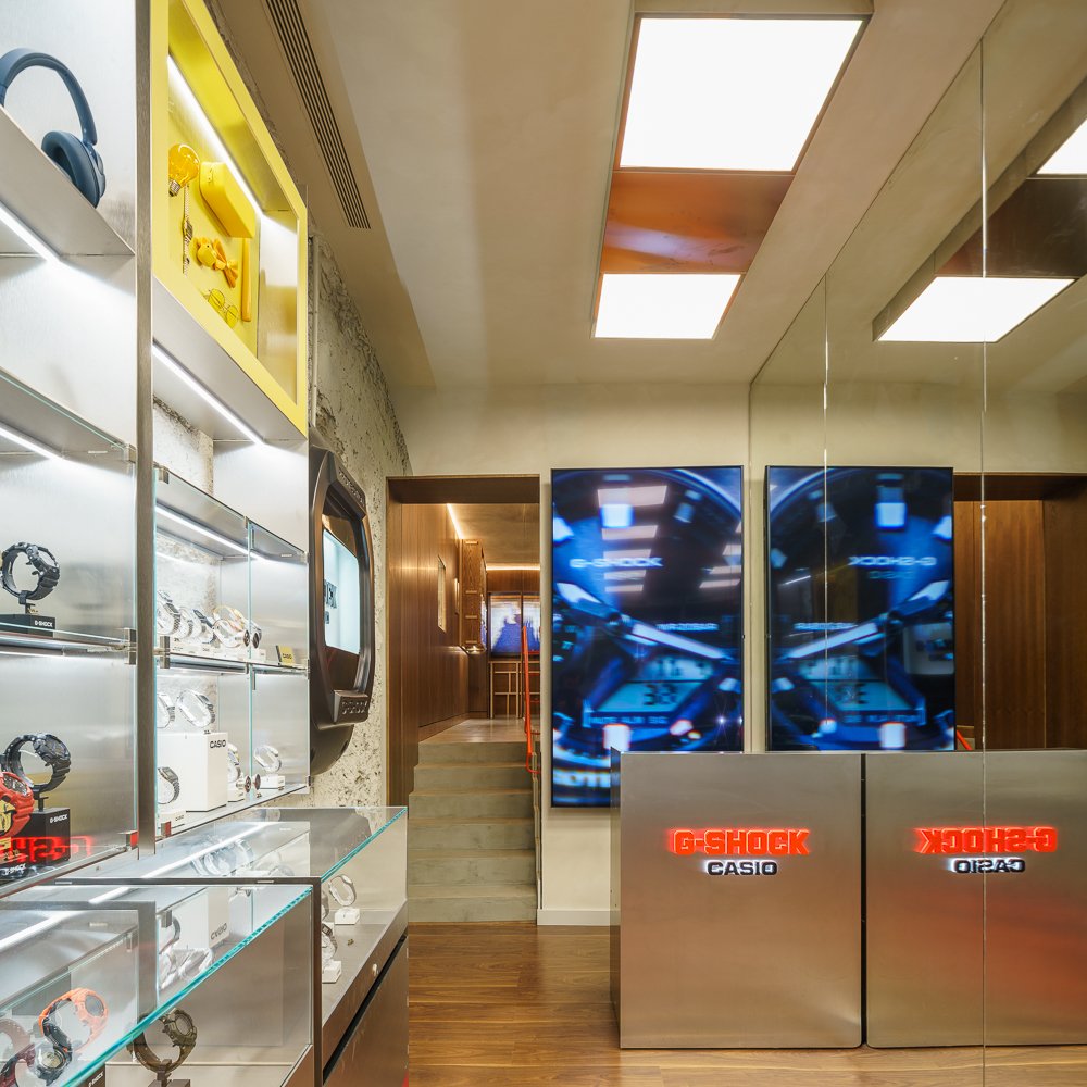 Tienda G-Shock: vitrinas de acero y vidrio, pantallas y mostrador con rótulo
