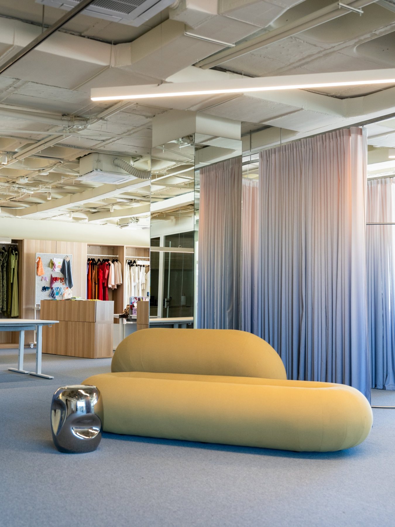 Oficinas de Lady Pipa: sofá curvo, cortinas degradadas y techo de instalaciones vistas