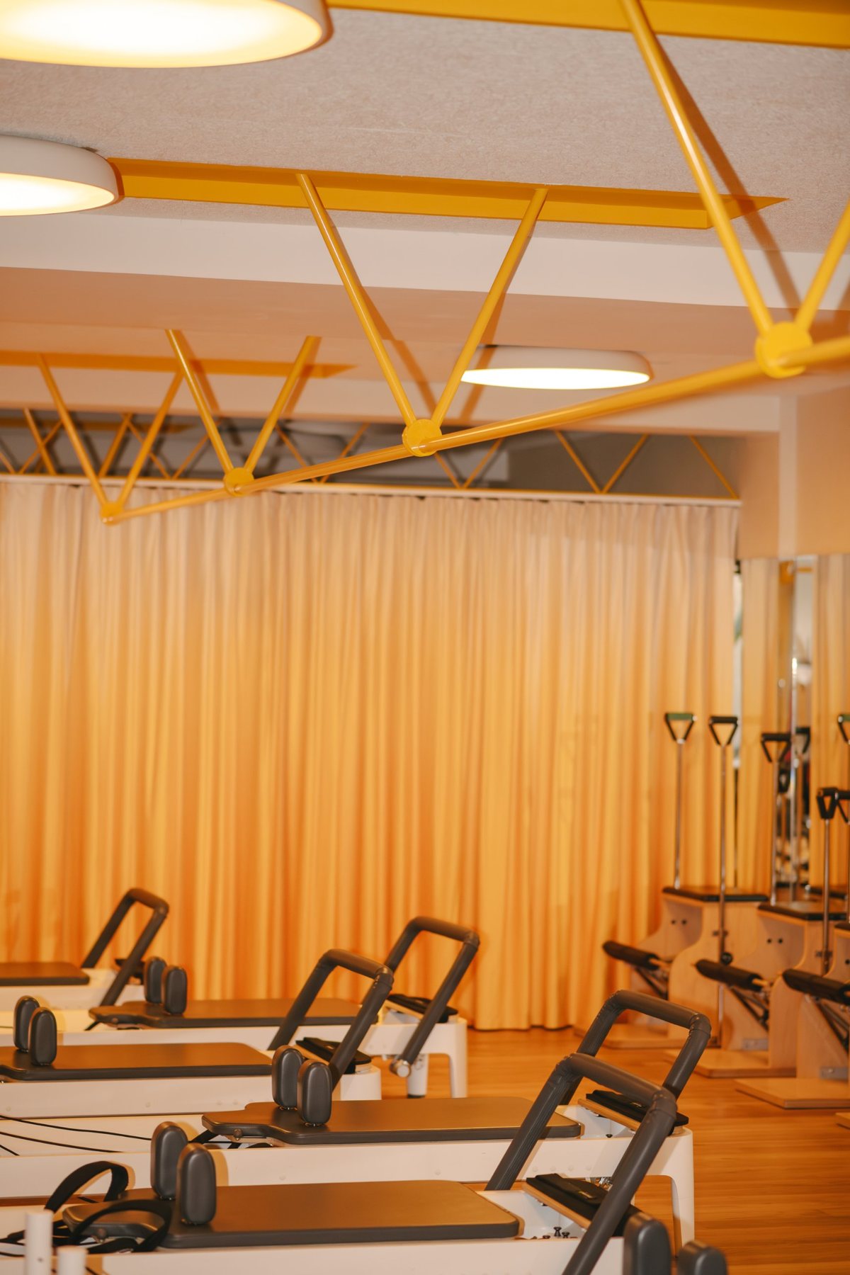 Prado Motion Pilates: estructura amarilla, cortina y máquinas de pilates